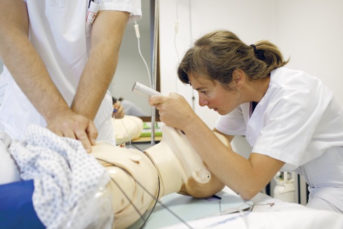 un soignant s'exerce sur un manequin